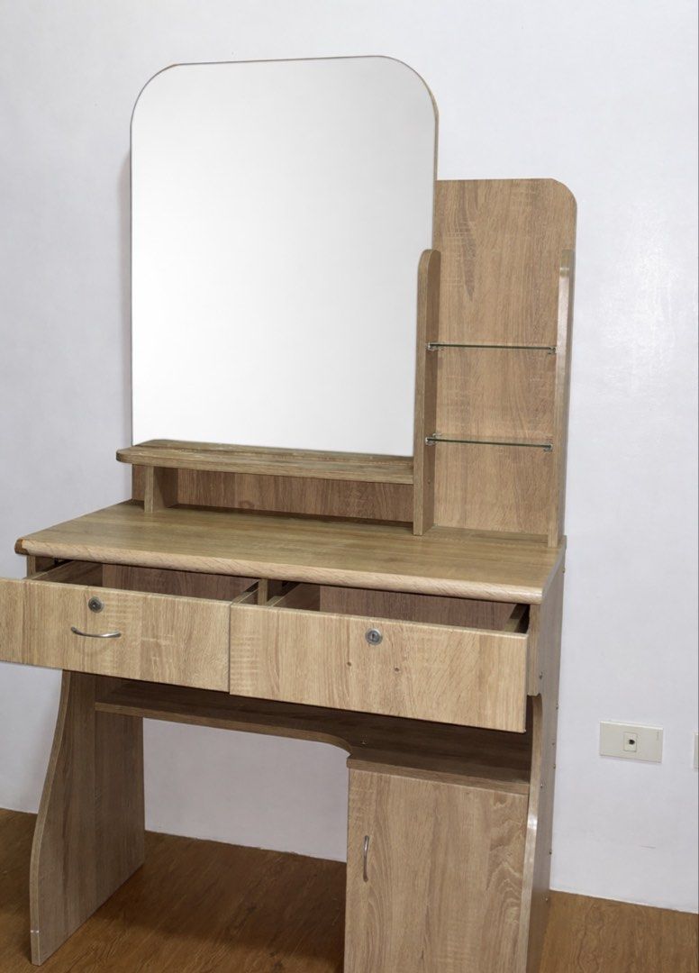 Wooden Vanity Table with Mirror (Category: Tables & Sets) located in Manila. Submitted by newbird-5396 (Listing ID 1437923978, Image 1). Description: - Wooden vanity table - Includes a mirror - Features two drawers - Has a cabinet for storage - Includes two small side shelves Dents: - No keys - No right handle (Drawer) - Bakbak pintura (only from the picture).