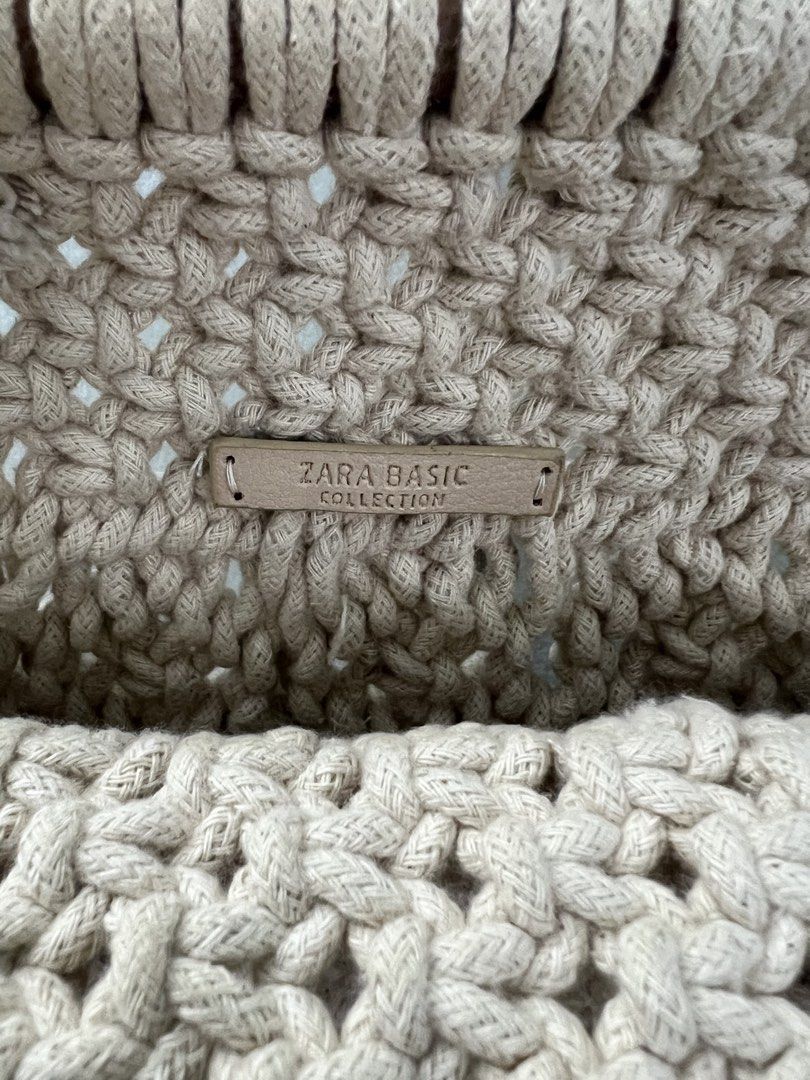 Zara Basic Macrame Handbag (Category: Shoulder Bags) located in Singapore. Submitted by ikml2015 (Listing ID 1437816115, Image 3). Description: Beautiful Zara Basic macrame handbag. Features a unique woven design with a tassel detail. The bag has sturdy handles and a wooden bar at the top. Perfect for adding a bohemian touch to any outfit..