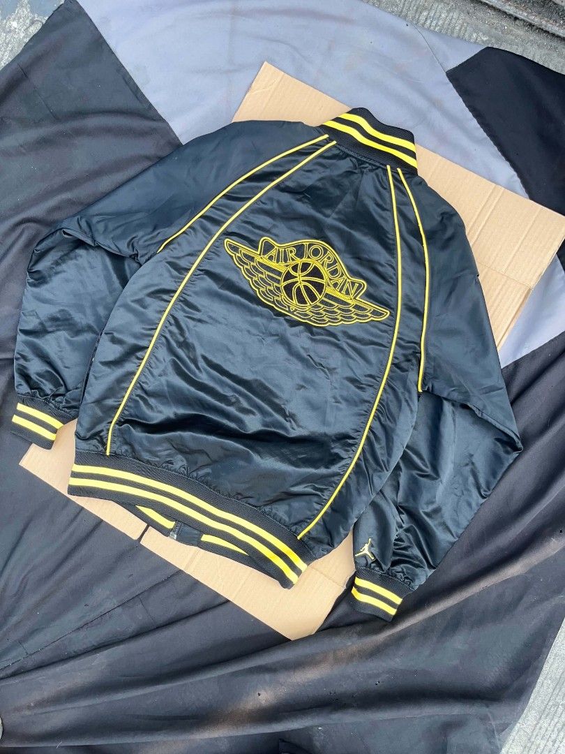 Air Jordan Black and Yellow Jacket (Category: Coats, Jackets and Outerwear) located in Manila. Submitted by jgabooo04 (Listing ID 1437951904, Image 2). Description: - Black jacket with yellow accents - Air Jordan logo on back and front - Button-up front - Striped collar and cuffs - Includes red Air Jordan tag - Size Medium .