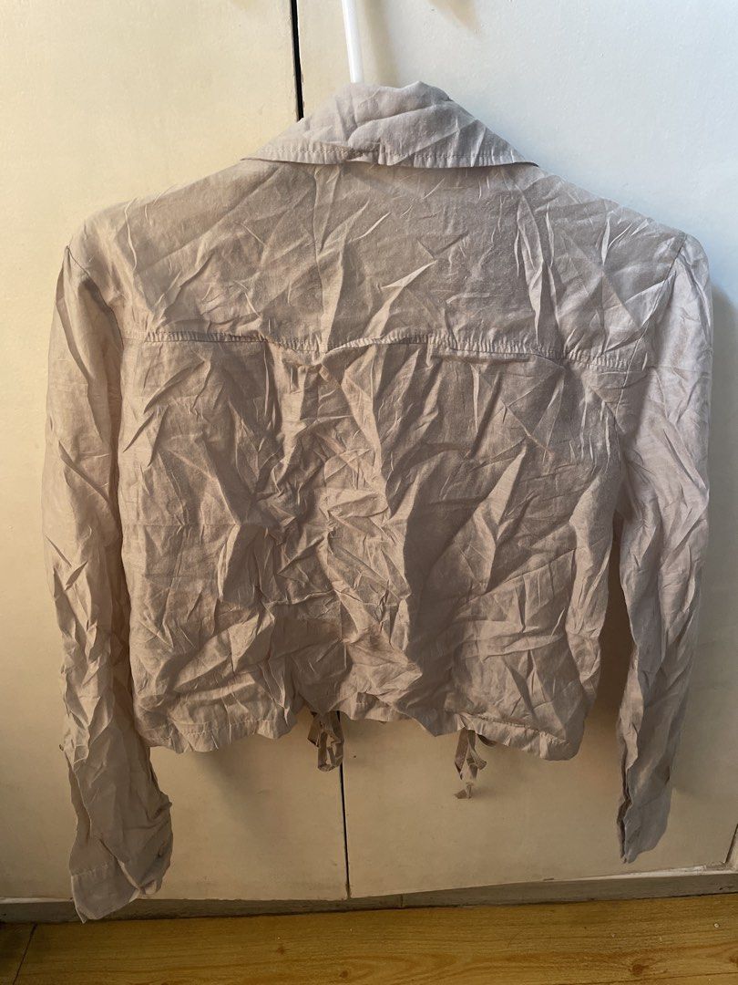 Beige Cropped Blouse with Drawstring (Category: Blouses) located in Paranaque City. Submitted by commandercinnabutt (Listing ID 1437978914, Image 2). Description: - Beige cropped blouse - Long sleeves - Collared neckline - Two front pockets - Drawstring hem - Button-down closure - Lightweight fabric - Versatile for different looks.