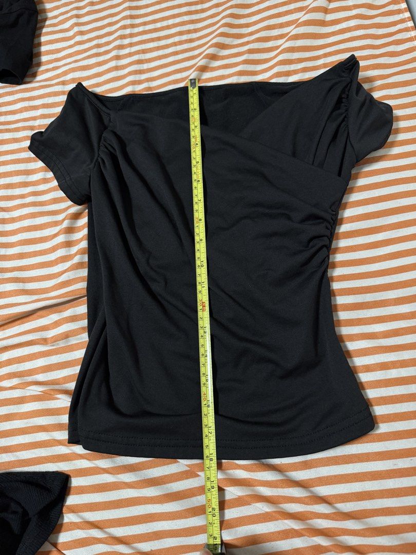 Black Off-Shoulder Top (Category: Blouses) located in Manila. Submitted by deluxelabphilippines (Listing ID 1438088682, Image 2). Description: - Black off-shoulder top - Draped front design - Short sleeves - Fitted silhouette - Measurements: - Length: 25 inches - Chest: 15 inches - Stretchy material.