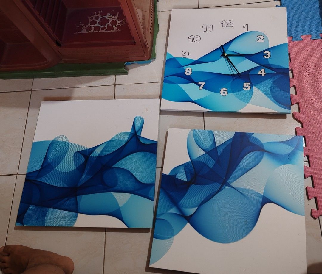 Blue Abstract Wall Clock and Art Set (Category: Wall Decor) located in Pasig City. Submitted by geraldnee28280 (Listing ID 1437993828, Image 2). Description: - Wall decor set includes: - 1 rectangular wall clock - 3 square wall art pieces - Features a blue abstract design. - Clock has gold-colored numbers and black hands. - Adds a modern touch to any room..