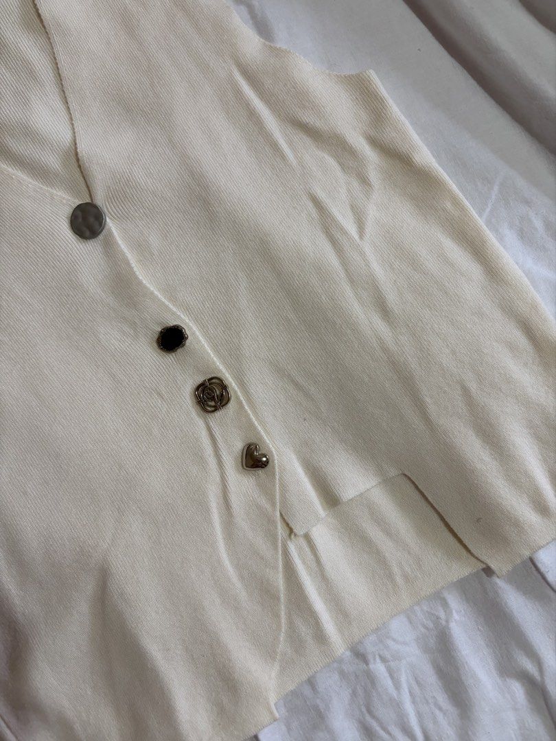 Cream-colored Button-up Vest (Category: Vests) located in Manila. Submitted by andreacap (Listing ID 1437965500, Image 2). Description: - Cream-colored knit vest - V-neckline - Decorative buttons: silver, black, rose-shaped, and heart-shaped - Sleeveless design - Slightly asymmetrical hemline 🎀 currently decluttering/selling pre-loved clothes, check my page for more details! 🎀 please manage expectations, you may send me a dm for more photos 🎀 