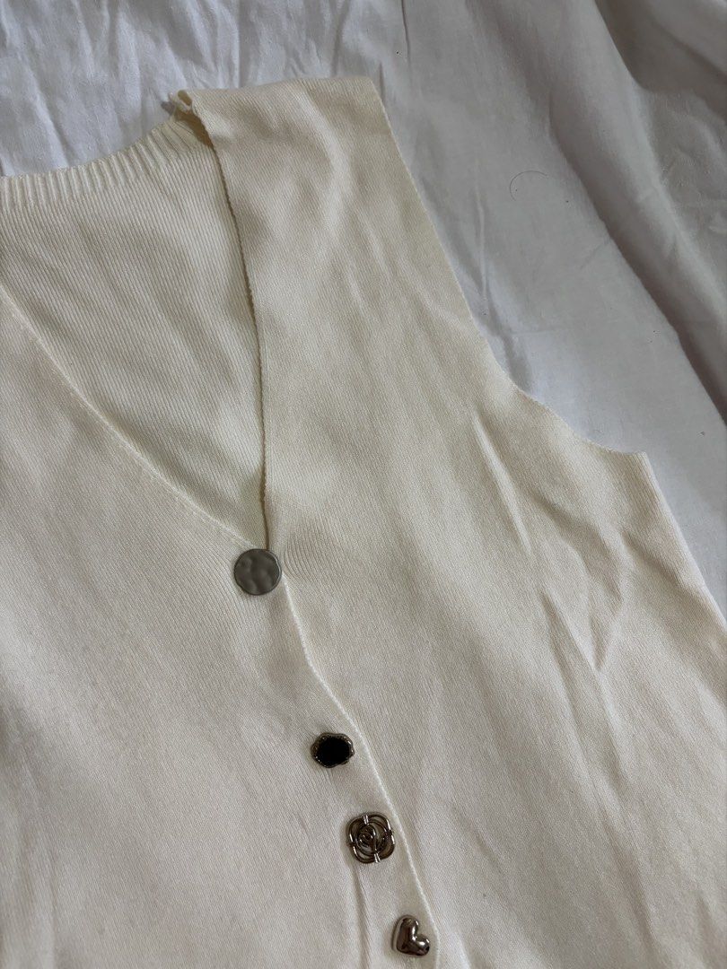 Cream-colored Button-up Vest (Category: Vests) located in Manila. Submitted by andreacap (Listing ID 1437965500, Image 3). Description: - Cream-colored knit vest - V-neckline - Decorative buttons: silver, black, rose-shaped, and heart-shaped - Sleeveless design - Slightly asymmetrical hemline 🎀 currently decluttering/selling pre-loved clothes, check my page for more details! 🎀 please manage expectations, you may send me a dm for more photos 🎀 