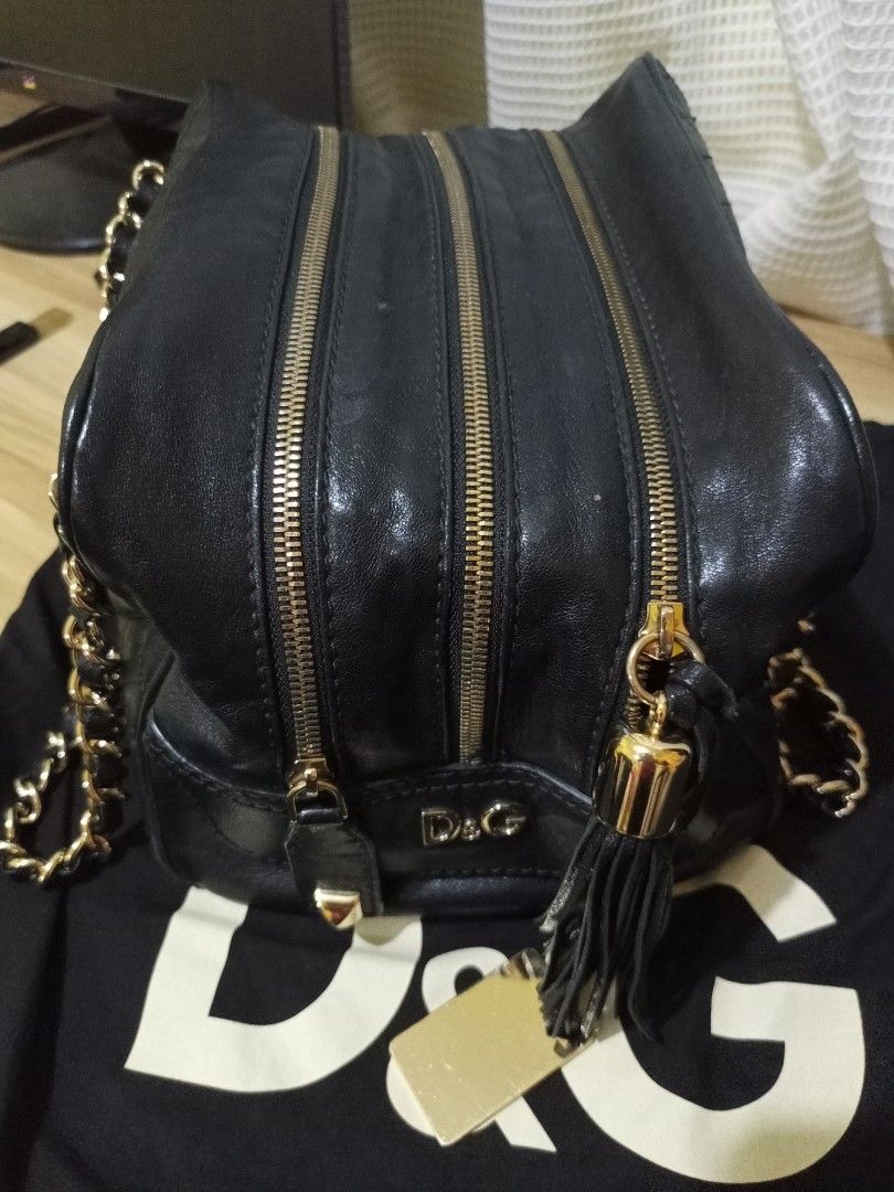 D&G Black Quilted Chain Bag (Category: Luxury Bags & Wallets) located in Marikina City. Submitted by greyz.regginne_27 (Listing ID 1438102160, Image 3). Description: - Authentic D&G handbag - Black quilted design - Gold chain straps - Multiple zipper details - Tassel accent - D&G logo on front - Includes dust bag - Gold tag: "D&G BAG LILY" - Made of leather.