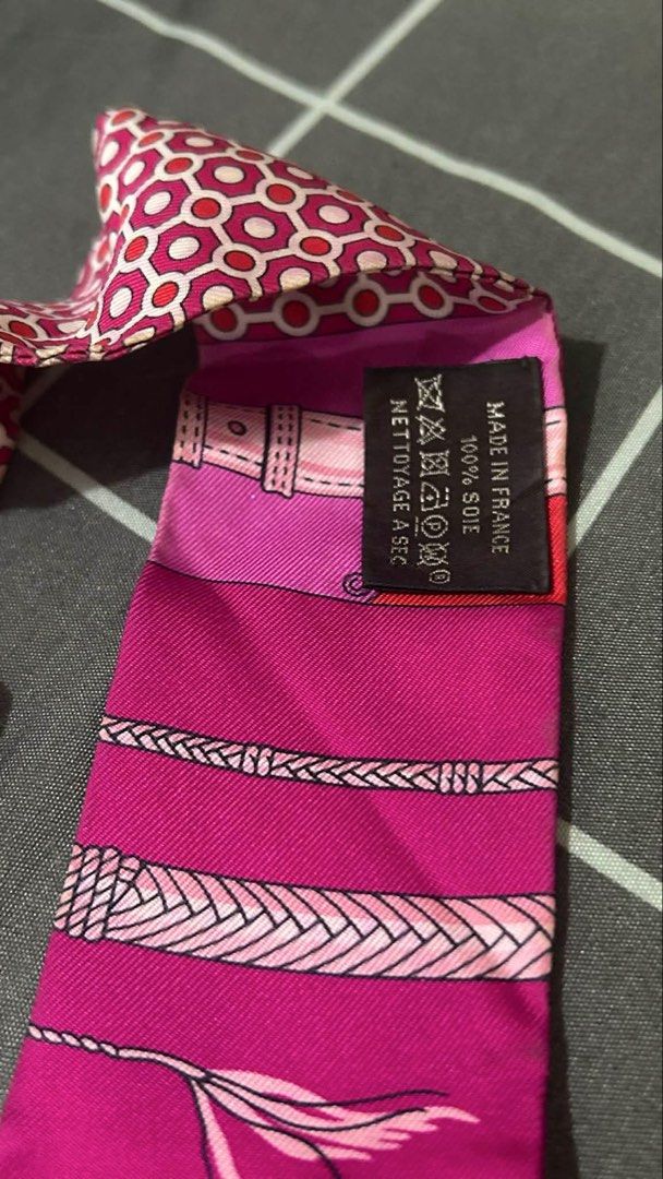 Hermès Silk Twilly Scarf (Category: Scarves) located in Taytay. Submitted by stph_declutters (Listing ID 1438068402, Image 3). Description: •Authentic Hermès silk twilly scarf •Vibrant pink and red color scheme •Intricate patterns •100% silk •used once / never been washed ORIGIN: Made in France Color: Fuchsia Size (LxW): 33.85" x 1.96" .