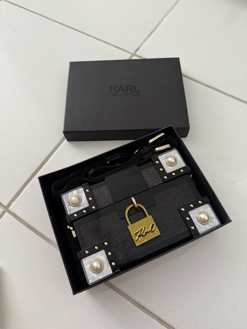 Karl Lagerfeld Black Handbag with Box (Category: Luxury Bags & Wallets) located in Makati City. Submitted by zivnd (Listing ID 1437994419, Image 1). Description: - Karl Lagerfeld handbag/shoulder bag/clutch - Black design with gold-colored hardware - Features pearl-like accents - Includes detachable strap - Comes with original box, tags, and cards - Interior is clean and barely used.