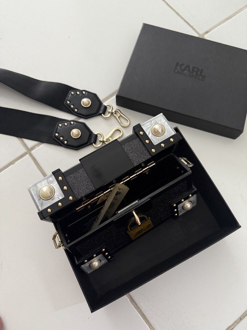 Karl Lagerfeld Black Handbag with Box (Category: Luxury Bags & Wallets) located in Makati City. Submitted by zivnd (Listing ID 1437994419, Image 2). Description: - Karl Lagerfeld handbag/shoulder bag/clutch - Black design with gold-colored hardware - Features pearl-like accents - Includes detachable strap - Comes with original box, tags, and cards - Interior is clean and barely used.
