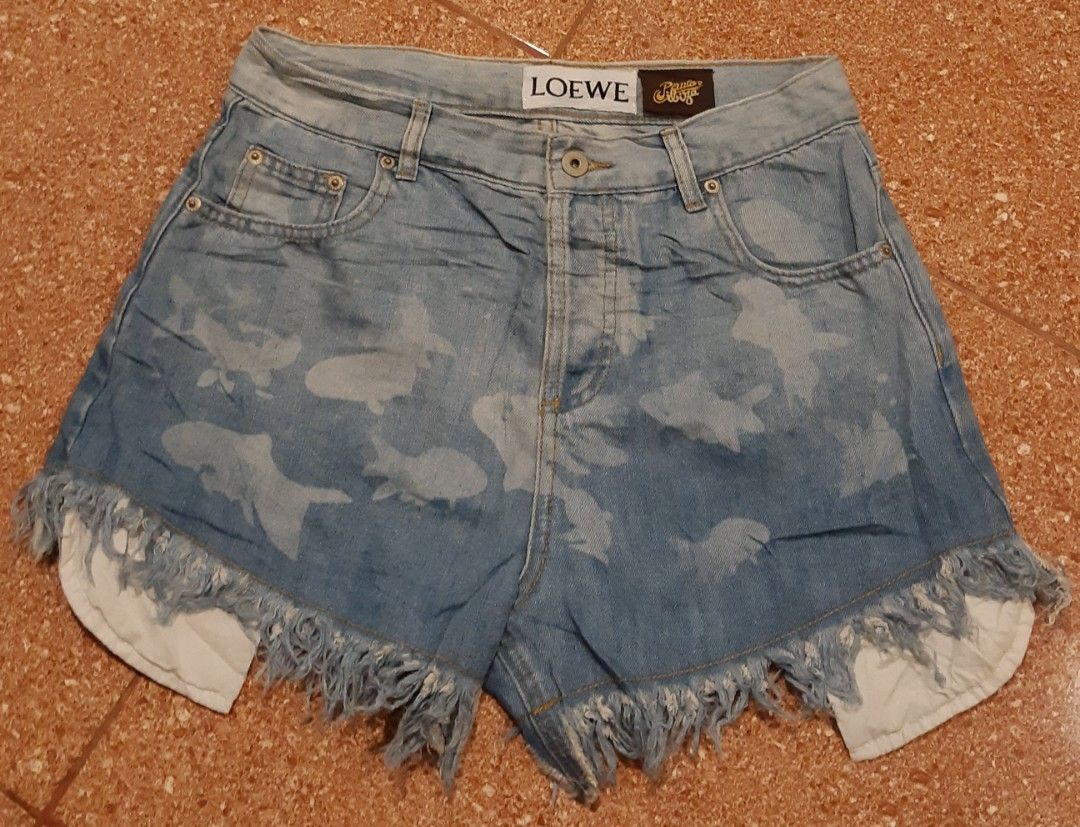Loewe Denim Shorts with Fish Print (Category: Shorts) located in Malaybalay. Submitted by rielstuff (Listing ID 1438062386, Image 1). Description: Stylish Loewe denim shorts featuring a unique fish print design. These shorts have a classic five-pocket design with a button closure. The shorts have a frayed hem and a light blue wash. The Loewe logo is visible on the waistband and inside the shorts. The shorts appear to be made of denim..