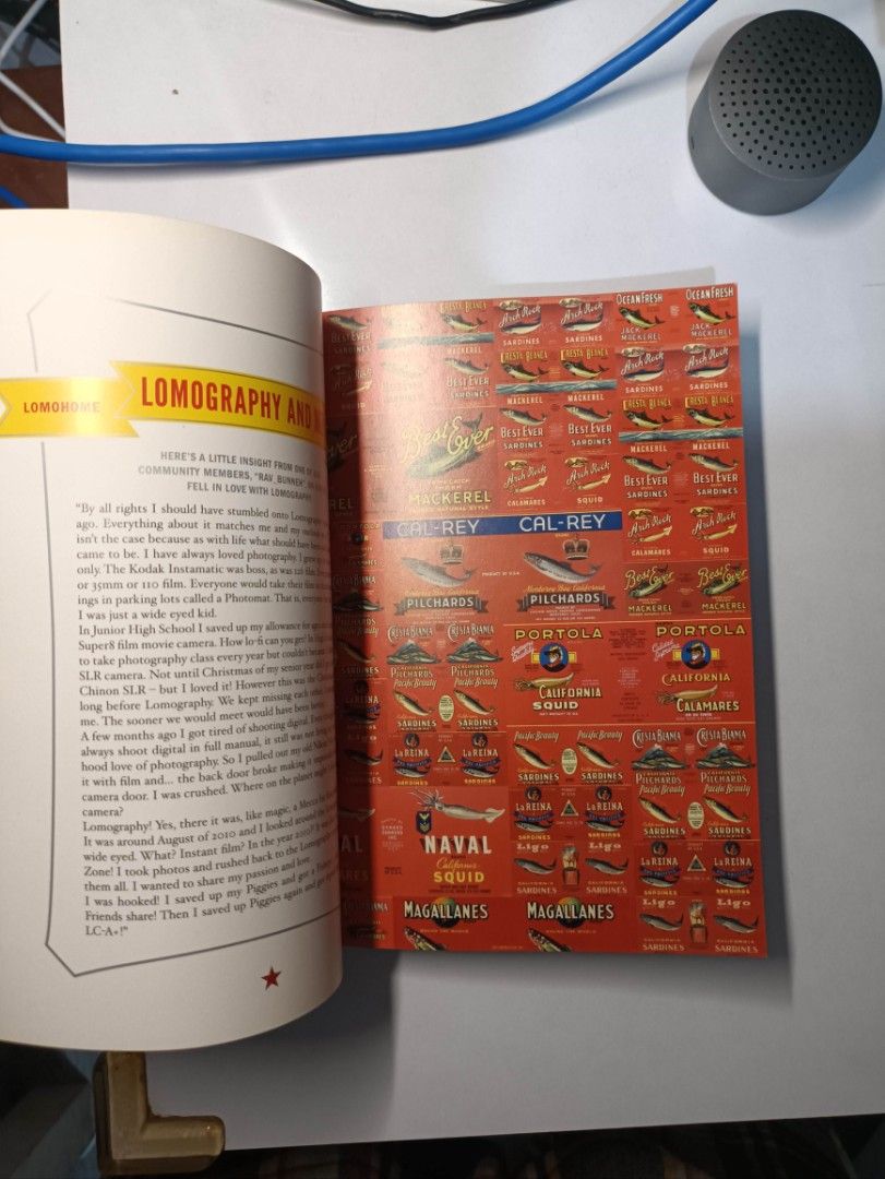 Lomography La Sardina Photobook (Category: Cameras) located in Bulacan. Submitted by jcob_ (Listing ID 1438064880, Image 3). Description: - "La Sardina: Seeing the World Through a Sardine Can" book. - Focuses on Lomography and photography. - Contains colorful illustrations and text. - Features images of sardine cans and light painting. - Includes information about various camera types..