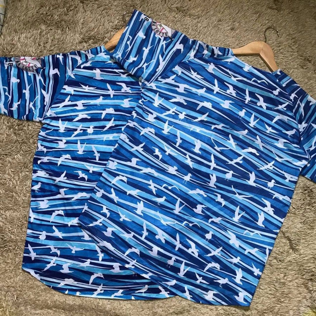 Marines Baseball Jersey (Category: Tshirts & Polo Shirts ) located in Navotas City. Submitted by jericafits (Listing ID 1438051759, Image 2). Description: - [ ] Marines Size:L Dimes:22.5 x 27.5-29.5 ₱ 300(2pcs Available) - Japanese baseball jersey - Blue and white bird pattern - "MARINES" text on front - Button-up design - Short sleeves.