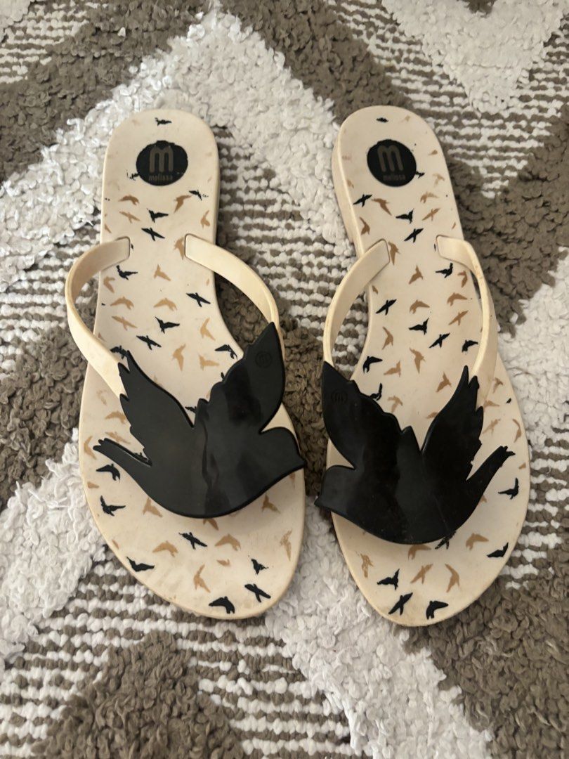 Melissa Sandals with Bow and Bird Design (Category: Flats & Sandals) located in Las Pinas. Submitted by livedog.eb2d1b (Listing ID 1438015409, Image 3). Description: 950 each. Stylish Melissa sandals featuring a bow detail and a bird design. The sandals are brown with a beige bow and a gold buckle. The other pair is a flip-flop style with a bird design. Both pairs are perfect for a casual and chic look..