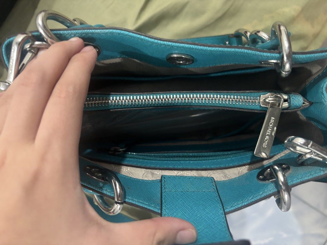 Michael Kors Turquoise Handbag with Chain Straps (Category: Luxury Bags & Wallets) located in Manila. Submitted by liaaa.415 (Listing ID 1437981989, Image 3). Description: - Michael Kors handbag in turquoise - Chain straps and detachable shoulder strap - Interior zippered compartment and pockets - Silver-tone hardware - Includes MK charm - Chic everyday accessory.