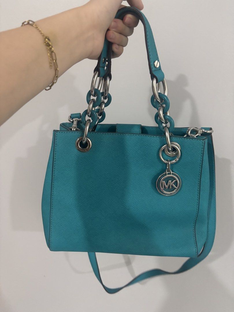 Michael Kors Turquoise Handbag with Chain Straps (Category: Luxury Bags & Wallets) located in Manila. Submitted by liaaa.415 (Listing ID 1437981989, Image 1). Description: - Michael Kors handbag in turquoise - Chain straps and detachable shoulder strap - Interior zippered compartment and pockets - Silver-tone hardware - Includes MK charm - Chic everyday accessory.
