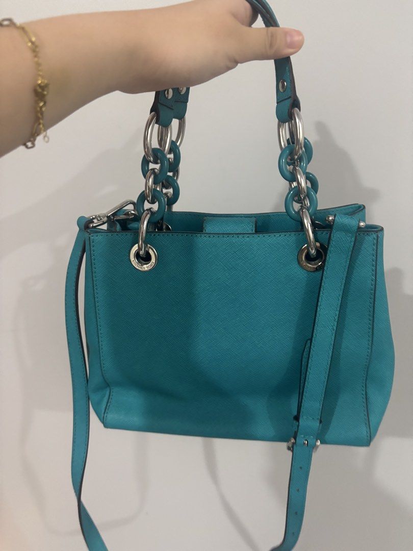 Michael Kors Turquoise Handbag with Chain Straps (Category: Luxury Bags & Wallets) located in Manila. Submitted by liaaa.415 (Listing ID 1437981989, Image 2). Description: - Michael Kors handbag in turquoise - Chain straps and detachable shoulder strap - Interior zippered compartment and pockets - Silver-tone hardware - Includes MK charm - Chic everyday accessory.