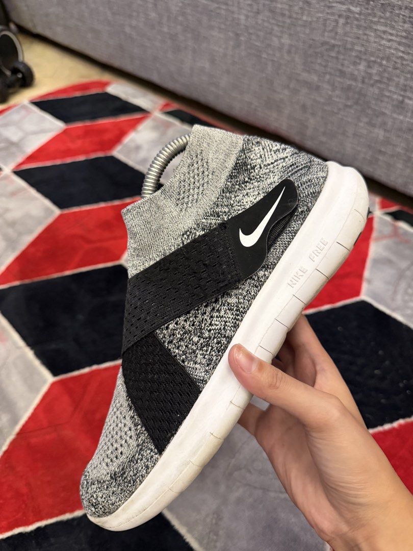Nike Free RN Flyknit 2018 Sneakers (Category: Sneakers) located in San Jose. Submitted by affordabletrendsby_cai (Listing ID 1438034213, Image 2). Description: Nike Free RN Flyknit 2018 sneakers. Features a gray and black Flyknit upper with a black strap and white sole. The Nike swoosh logo is visible on the side. The sole is white with "NIKE FREE" printed on the side. The shoes have a sock-like fit..