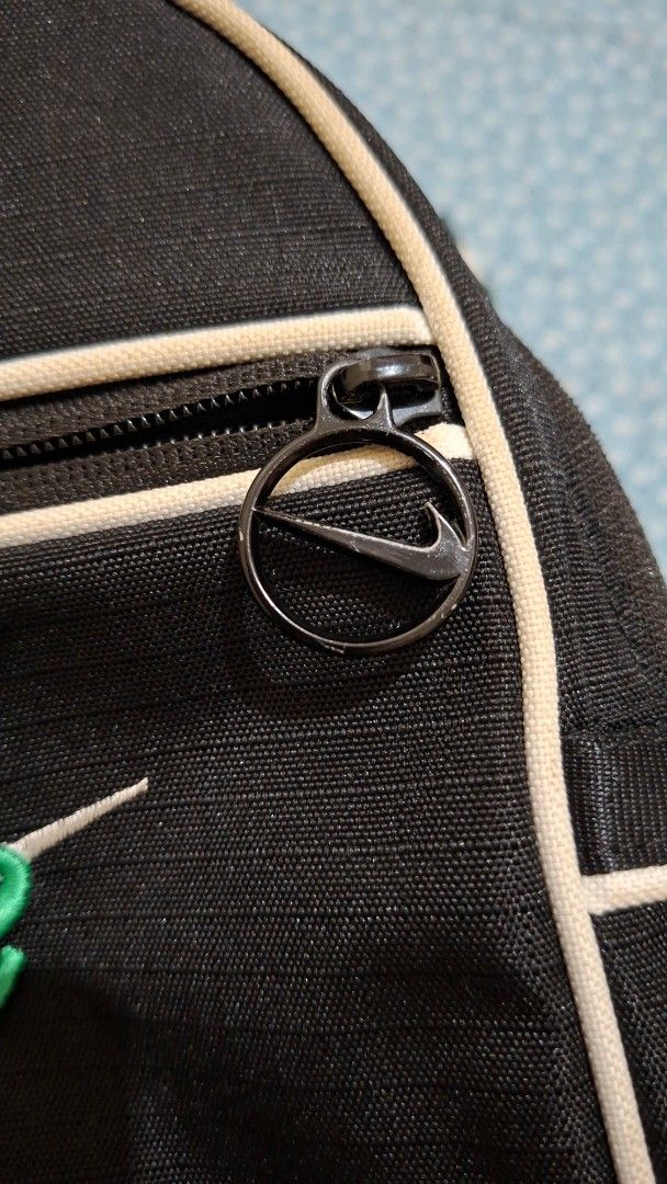 Nike Mini Backpack Black (Category: Backpacks) located in Pasig City. Submitted by kkdvm (Listing ID 1438080870, Image 3). Description: - Nike mini backpack - Black exterior with white trim - Green and white striped strap - Nike logo on front - Zipper closure - Compact size - Ideal for small items - Minor imperfection on strap.