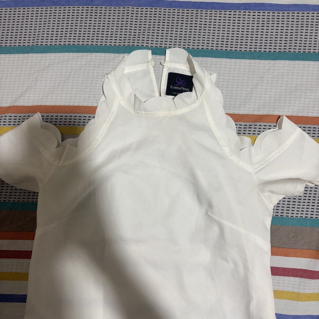Plains & Prints White Cold Off Shoulder Ruffle Top (Category: Blouses) located in Davao. Submitted by _manuella (Listing ID 1438009422, Image 1). Description: - Plains & Prints cold shoulder top - Size 4 - High neckline with scalloped edge - Short sleeves - Keyhole back closure - Lightweight fabric - Ideal for warm weather - Suitable for casual and semi-formal occasions.