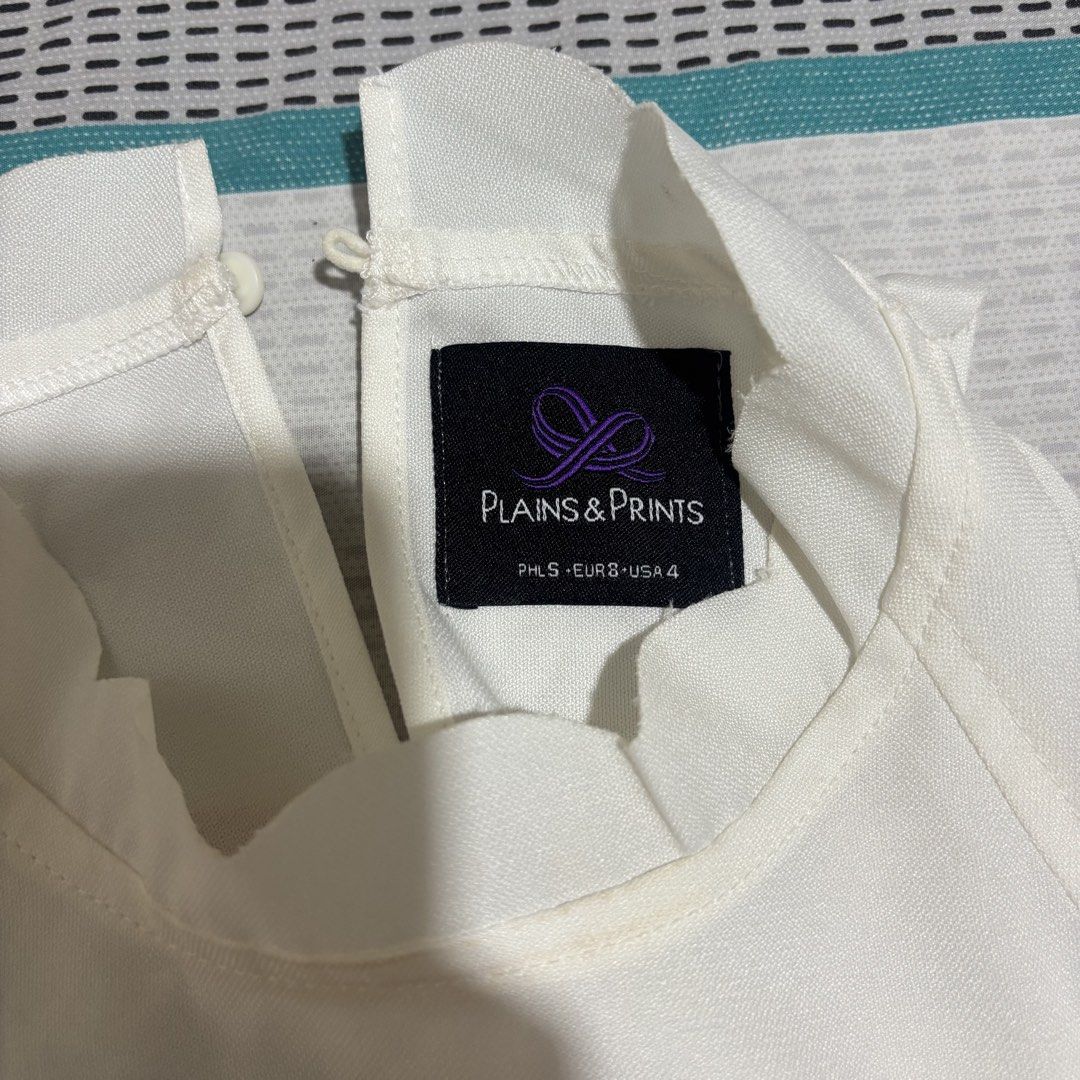 Plains & Prints White Cold Off Shoulder Ruffle Top (Category: Blouses) located in Davao. Submitted by _manuella (Listing ID 1438009422, Image 2). Description: - Plains & Prints cold shoulder top - Size 4 - High neckline with scalloped edge - Short sleeves - Keyhole back closure - Lightweight fabric - Ideal for warm weather - Suitable for casual and semi-formal occasions.