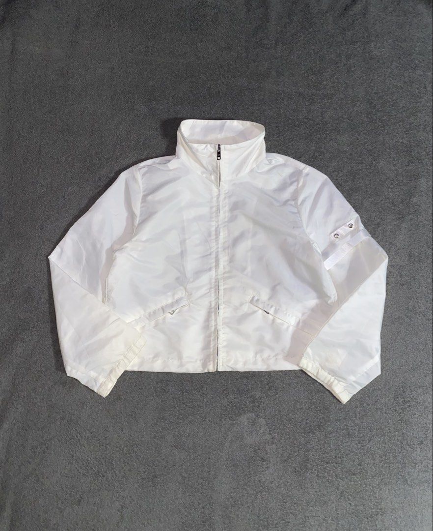 Prada White Cropped Jacket (Category: Coats, Jackets and Outerwear) located in Cebu City. Submitted by arcane_thrift (Listing ID 1437945275, Image 1). Description: - Cropped jacket - High collar - Full-length zipper with Prada Milano zipper pulls - Two front pockets - Drawstring hem - Strap detail on sleeves.