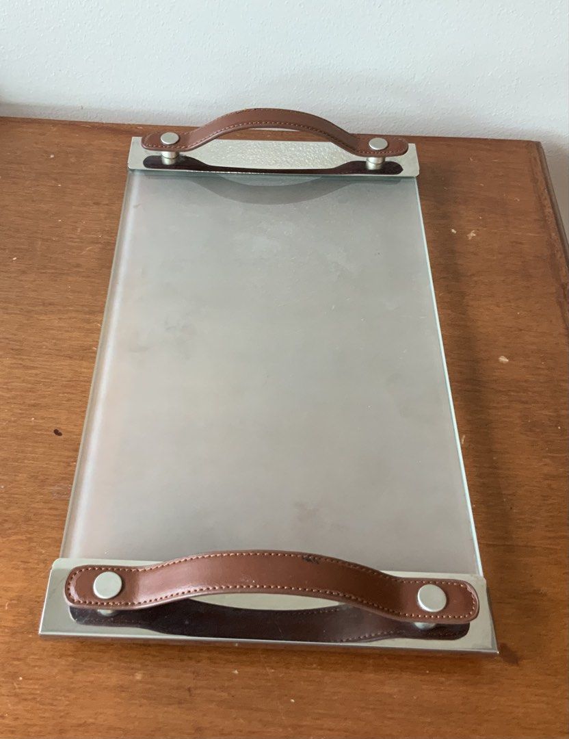 Rectangular glass serving tray with brown faux leather handles (Category: Other Kitchenware & Tableware) located in Makati City. Submitted by nfb1234 (Listing ID 1438001290, Image 1). Description: Check out this elegant rectangular serving tray! It features a sleek glass surface with stylish brown faux leather handles. Perfect for serving drinks or snacks, it adds a touch of sophistication to any occasion. RFS - declutter. Packaging not original 