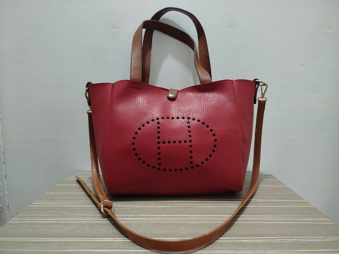 Reversible Two-Tone Tote/Crossbody Bag (Category: Shoulder Bags) located in Cavite. Submitted by prncs.jc (Listing ID 1437994181, Image 1). Description: Product Description: - Item: Reversible Two-Tone Tote/Crossbody Bag - Color: Red and Black (Reversible) with Tan straps - Material: Genuine Leather - Closure: Magnetic snap button tab - Handle/Strap: Dual top handles and a detachable, adjustable tan leather shoulder strap Interior: - Spacious ope