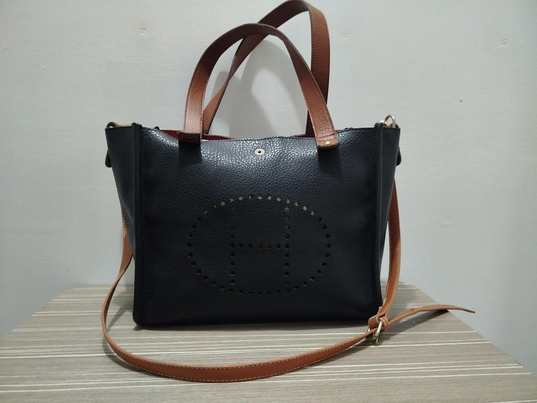 Reversible Two-Tone Tote/Crossbody Bag (Category: Shoulder Bags) located in Cavite. Submitted by prncs.jc (Listing ID 1437994181, Image 2). Description: Product Description: - Item: Reversible Two-Tone Tote/Crossbody Bag - Color: Red and Black (Reversible) with Tan straps - Material: Genuine Leather - Closure: Magnetic snap button tab - Handle/Strap: Dual top handles and a detachable, adjustable tan leather shoulder strap Interior: - Spacious ope