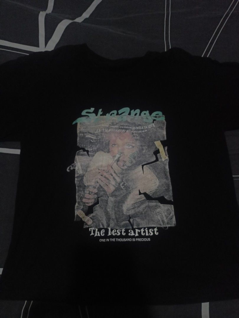 Strange The Lost Artist Graphic Tee (Category: Tshirts & Polo Shirts ) located in Manila. Submitted by around_marikina (Listing ID 1438099165, Image 3). Description: - Black graphic tee - Front print: Person with "Strange" and "The lost artist" - Back print: "Strange" - Short sleeves - Crew neck.