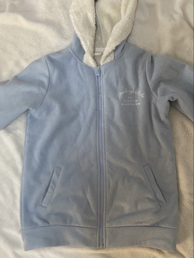 Topvalu Blue Fleece Jacket with Hood (Category: Coats, Jackets and Outerwear) located in Mabalacat. Submitted by cllctbls_ (Listing ID 1438010737, Image 1). Description: - Topvalu blue fleece jacket - Cozy white fur-lined hood - Full zipper closure - Features a printed design on the chest - Two front pockets - Size 140 - Hood lining: White - Material: 100% polyester.