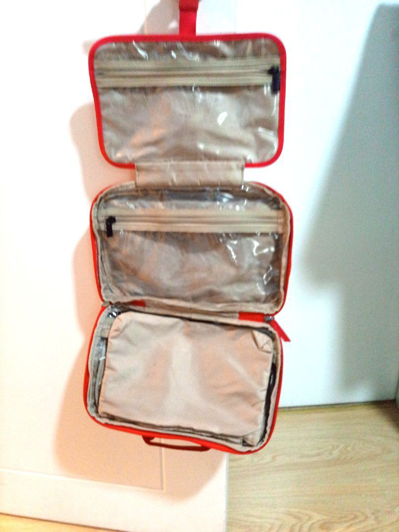 Tumi Red Hanging Travel Organizer (Category: Accessory Holder, Box & Organizers) located in Pasig City. Submitted by matmat1031 (Listing ID 1438028927, Image 2). Description: - Tumi travel organizer - Vibrant red color - Multiple compartments for organized storage - Includes zippered pockets - Convenient hanging design - Top handle for easy carrying - Durable material (possibly nylon) - Neutral-colored interior lining.