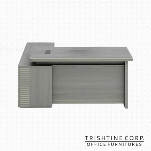 TXT-070 L-Shaped Office Desk (Category: Office Furniture & Fixtures) located in Caloocan City. Submitted by trishtine_jim9 (Listing ID 1437985818, Image 1). Description: - L-shaped office desk - Brand: Trishtine Corp. - Color: Light gray wood finish - Features a built-in drawer unit (2 drawers) and cabinet - Rectangular shape - Built-in cable management port - Ideal for office or home office.