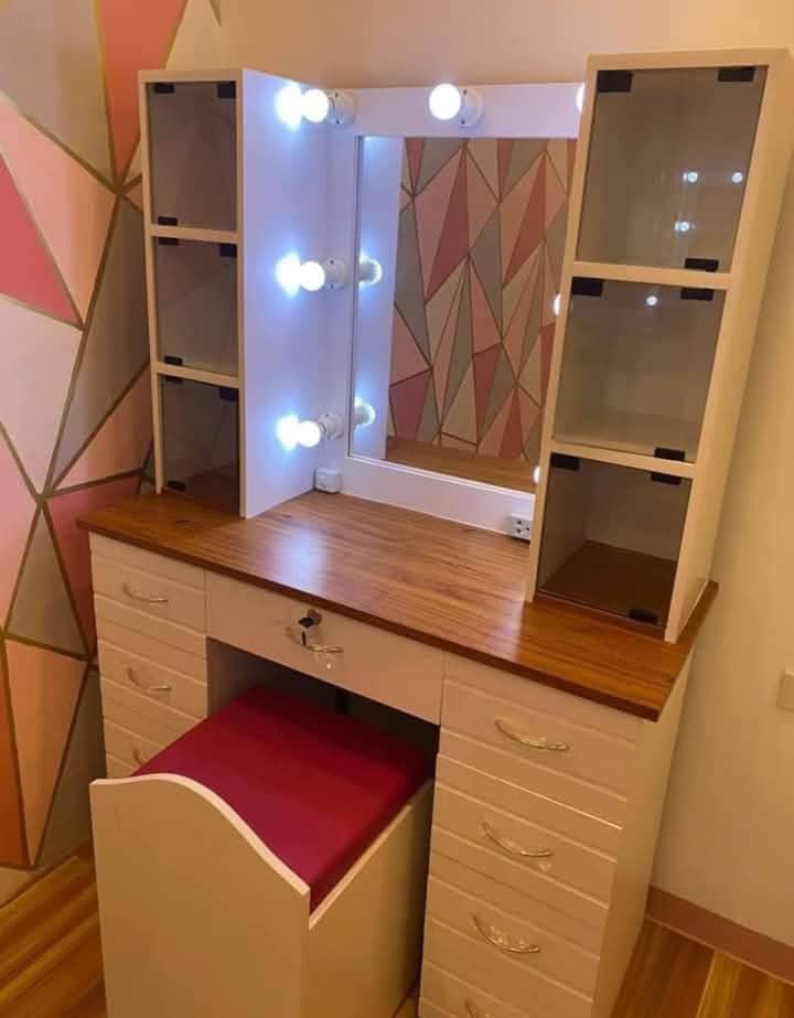 Vanity Table with Lights and Stool (Category: Tables & Sets) located in Mabalacat. Submitted by joemamangun01 (Listing ID 1437989024, Image 1). Description: - Vanity table with built-in mirror and lights - Multiple drawers and side cabinets for storage - Includes matching stool with cushioned seat - Wooden table top - White frame - Ideal for bedroom or dressing area.