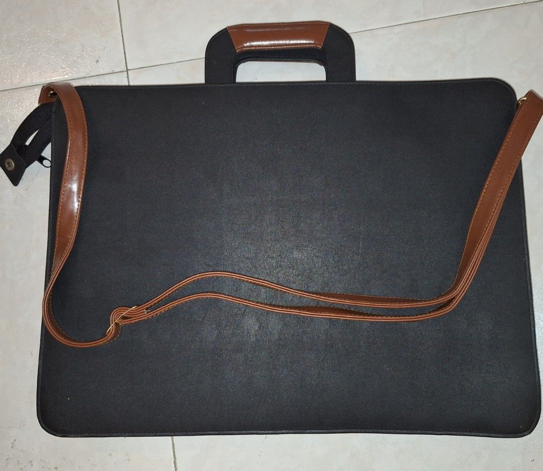 Classic Brown Briefcase (Category: Briefcases) located in Singapore. Submitted by hk267066 (Listing ID 1437726335, Image 2). Description: Vintage black, brown briefcase with shoulder strap and two untarnished gold buckle closures. Excellent condition. Size: 43cm Length by 33 cm Breadth. Perfect for carrying documents or a laptop. Self-collection. New one may cost about $500..