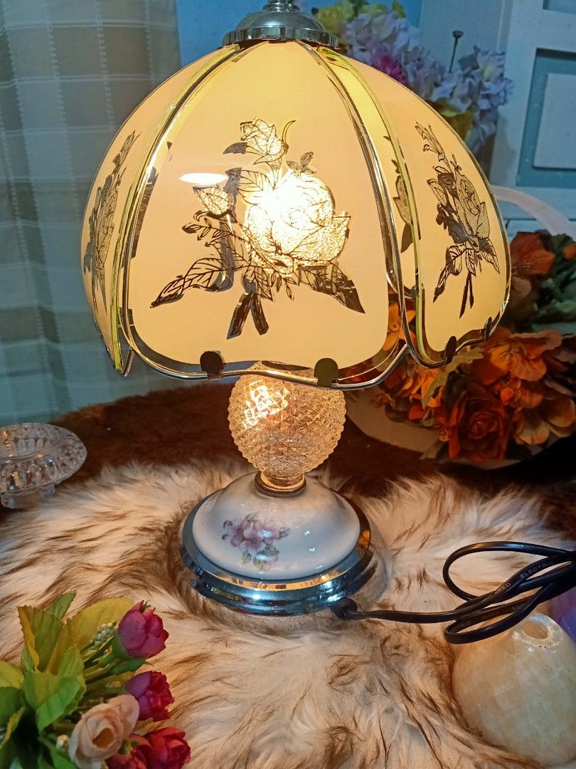 Vintage Tiffany Style Touch Lamp (Category: Lighting) located in Meycauayan. Submitted by youngdeer.86663a (Listing ID 1437938556, Image 1). Description: Elegant vintage table lamp featuring a floral design on the lampshade. The lamp has a decorative base with floral accents and a crystal-like sphere. It has a silver-colored metal base and a matching top. The lamp is designed to provide soft, ambient lighting, perfect for adding a touch of vintag