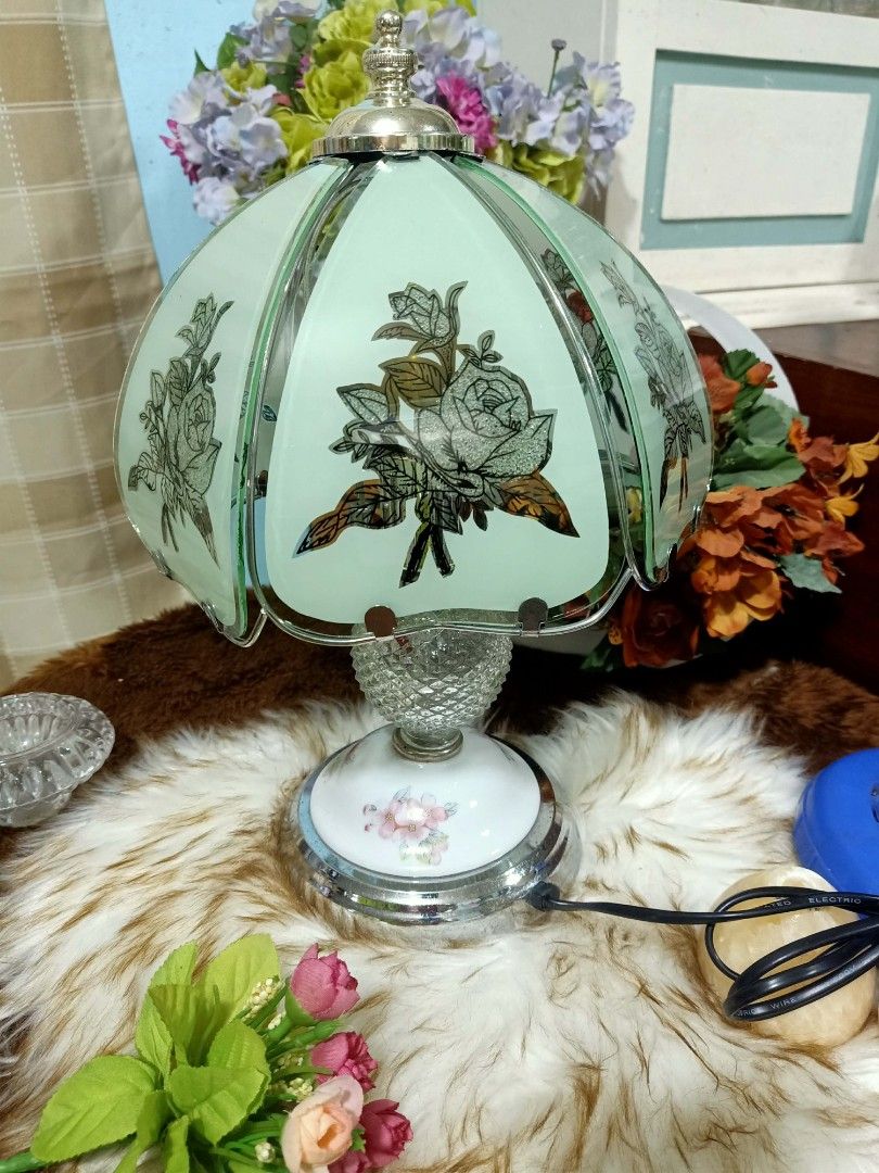 Vintage Tiffany Style Touch Lamp (Category: Lighting) located in Meycauayan. Submitted by youngdeer.86663a (Listing ID 1437938556, Image 2). Description: Elegant vintage table lamp featuring a floral design on the lampshade. The lamp has a decorative base with floral accents and a crystal-like sphere. It has a silver-colored metal base and a matching top. The lamp is designed to provide soft, ambient lighting, perfect for adding a touch of vintag