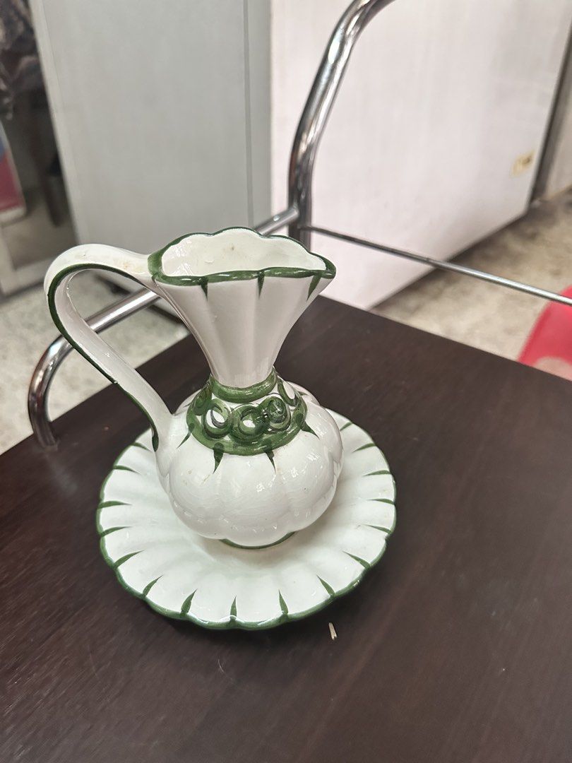 White Ceramic Pitcher with Saucer (Category: Coffee & Tea Tableware) located in Quezon City. Submitted by mystictiger.019d9c (Listing ID 1438108168, Image 1). Description: - White ceramic pitcher and matching saucer. - Unique design with green accents. - Pitcher has a handle and flared top. - Saucer with scalloped edge. - Ideal for display or serving. - Adds a lovely touch to your home decor..
