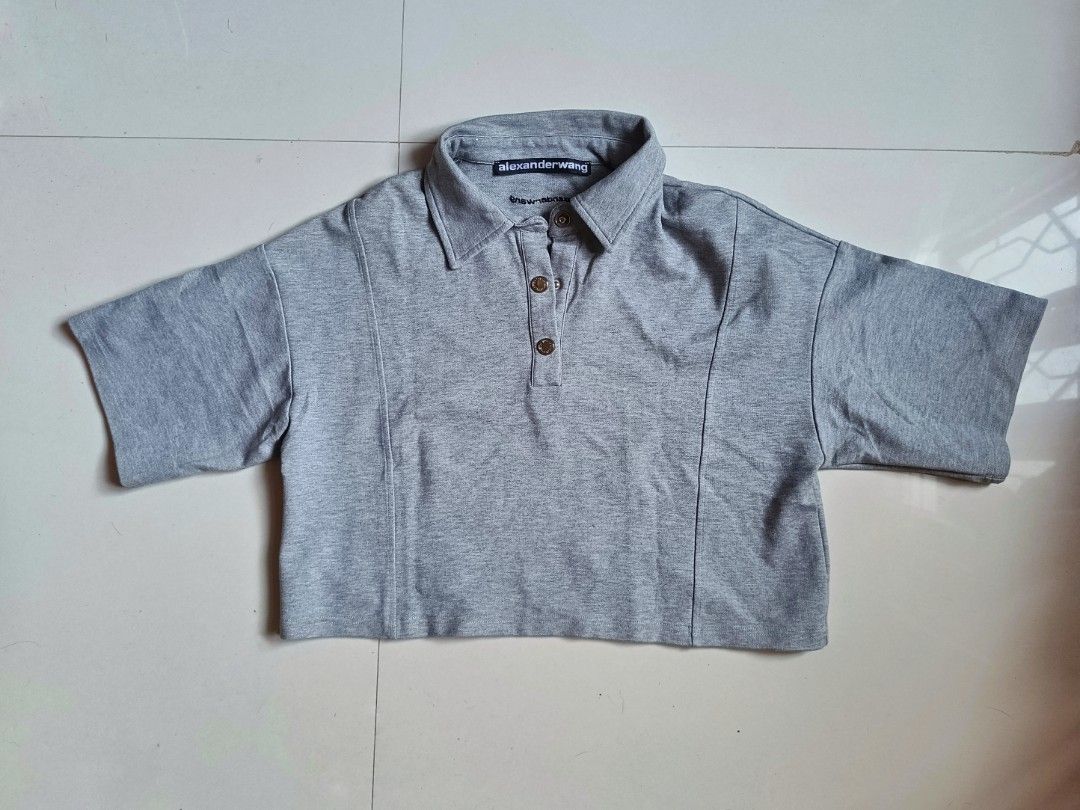 Alexander Wang Cropped Polo Shirt (Category: Tshirts & Polo Shirts ) located in Cabuyao City. Submitted by burberrymaki (Listing ID 1438176460, Image 1). Description: - Alexander Wang cropped polo shirt - Color: Gray - Size: M (fit to s-m) - Features a collared neckline - Short sleeves - Button closure - 100% cotton.