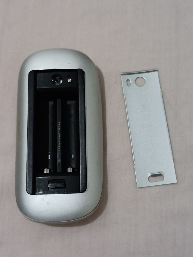 Apple Magic Mouse (Category: Mouse & Mousepads) located in Caloocan City. Submitted by bg_geniusph (Listing ID 1438231351, Image 2). Description: - Apple Magic Mouse - Silver finish - Requires 2 AA batteries (not included) - Includes battery compartment cover - Apple logo visible.