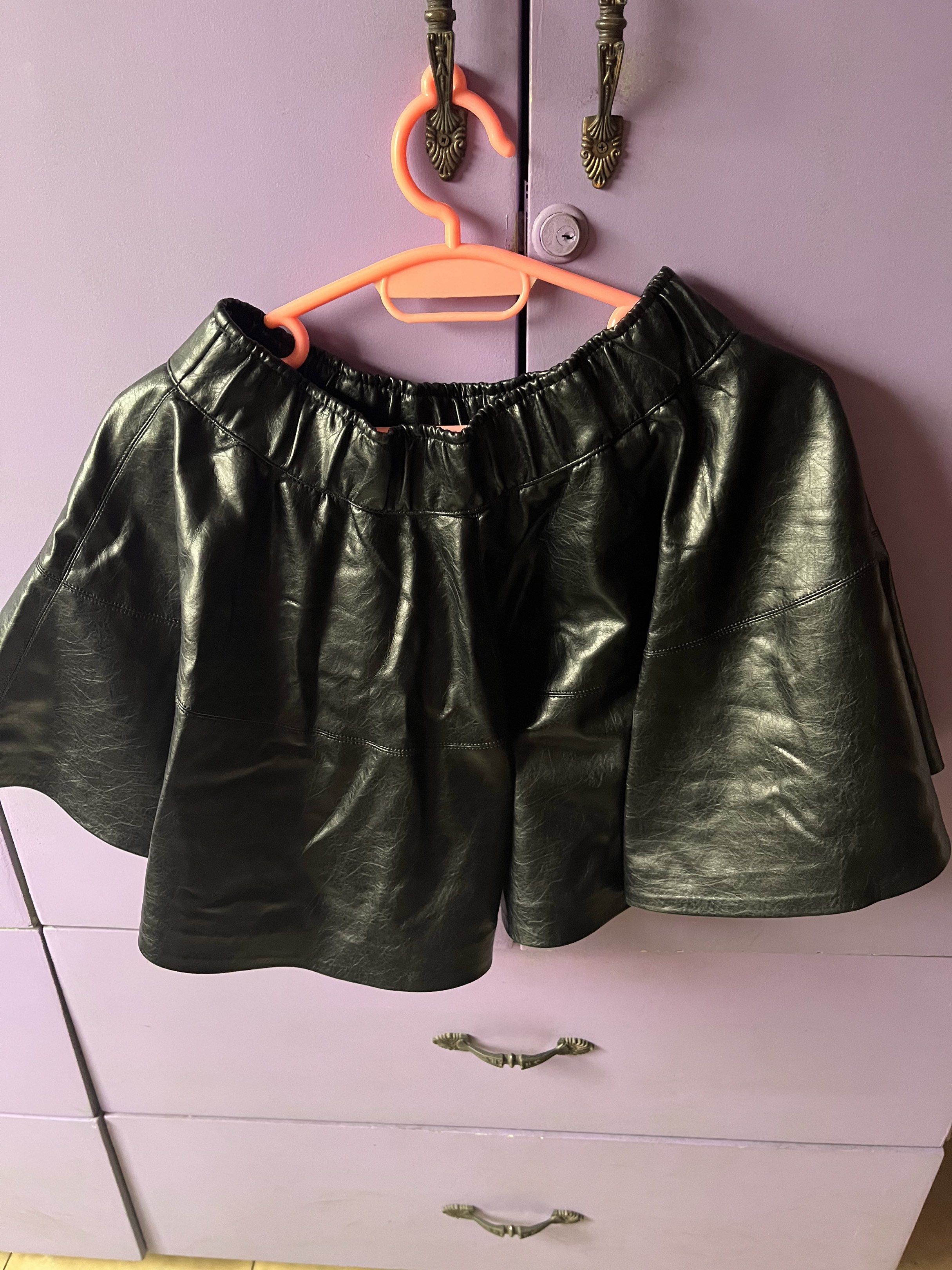 Black Leather Skirt (Category: Skirts) located in Marikina City. Submitted by dominique_s (Listing ID 1438174231, Image 2). Description: - Black faux leather mini skirt - Features an elastic waistband - Flared design - Versatile for various outfits - Can be dressed up or down.