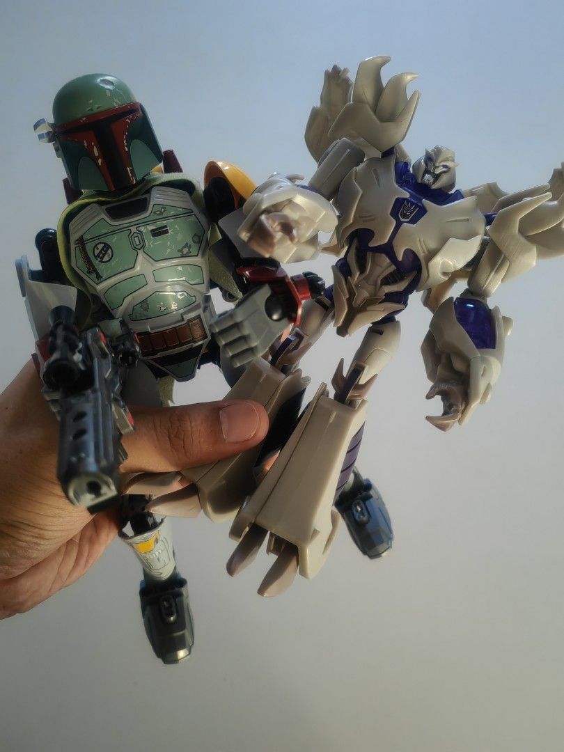Boba Fett and Megatron Action Figures (Category: Figurines & Statues) located in Naga. Submitted by bugoy_1988 (Listing ID 1438236455, Image 2). Description: - Collectible action figures featuring Boba Fett and Megatron. - Boba Fett: - Iconic green and gray armor. - Includes a blaster. - Megatron: - Robot form. - Silver and purple color scheme. - Well-detailed and poseable figures. - Displayed on a box..