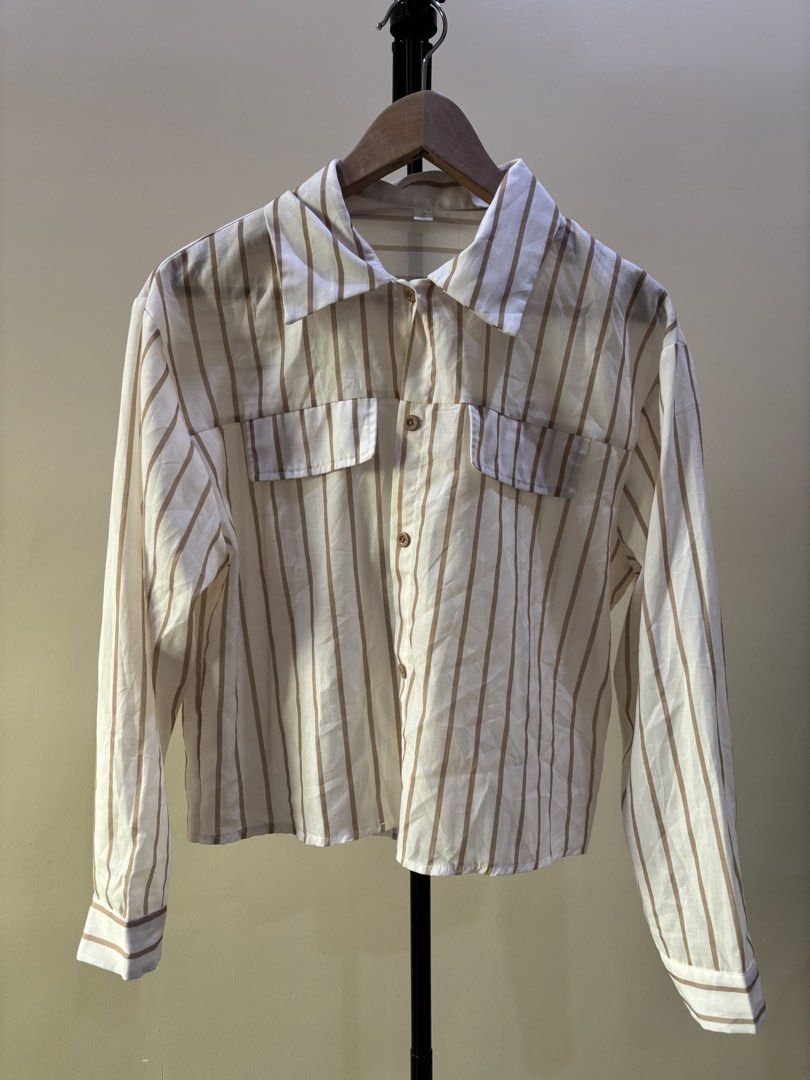Brown stripes office blouse (Category: Shirts) located in Quezon City. Submitted by declutternami (Listing ID 1438205017, Image 1). Description: - Striped button-down shirt - Color: White and brown stripes - Features two front pockets - Long sleeves with buttoned cuffs - Collared neckline - Button-up front closure - Made of lightweight fabric Medium size rfs: Declutter Pickup only: QC loc.
