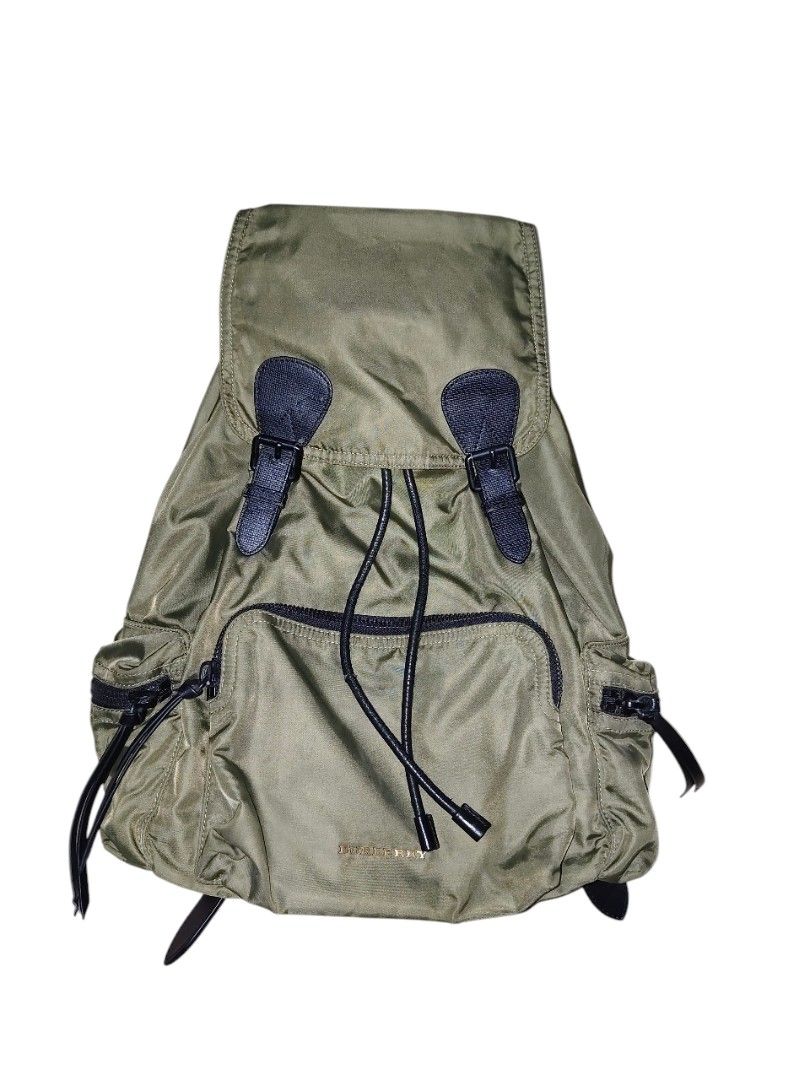 Burberry Nylon Rucksack Backpack (Category: Luxury Bags & Wallets) located in Munoz. Submitted by harm0nica337 (Listing ID 1438251778, Image 2). Description: - Olive green backpack with black accents - Drawstring closure and top handle Thrifted item : self authenticated only Flaws: tear on inner lining, tear on one side of compartment, peeling and other issues as shown in the last pics mop: gcash (price +SF) j&t express.