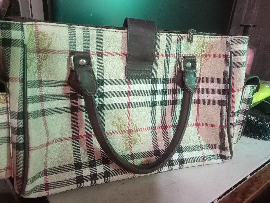 Burberry London Handbag (Category: Luxury Bags & Wallets) located in Caloocan City. Submitted by youngocean-27a69b (Listing ID 1438125806, Image 2). Description: Burberry Bag ( Off/Legit ) Issue: Rust, some cracks, minimal lose stitch sa handle, and isang small puller sa loob wala pero working lahat ng zip ₱299 shipped 📍 Guiguinto, Bulacan 🚚 Courier: J&T DM for more info 📩📩📩.