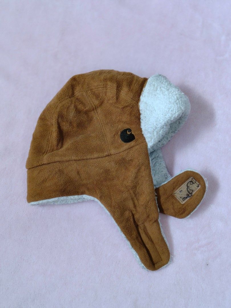 Carhartt Infant/Toddler Hat (Category: Babies & Kids Fashion) located in Siquijor. Submitted by retrothreads-r18 (Listing ID 1438122125, Image 1). Description: - Carhartt hat for infants and toddlers - Color: Brown exterior, light blue interior - Material: Polyester - Features: Button closure, ear flaps for warmth - Made in Cambodia.