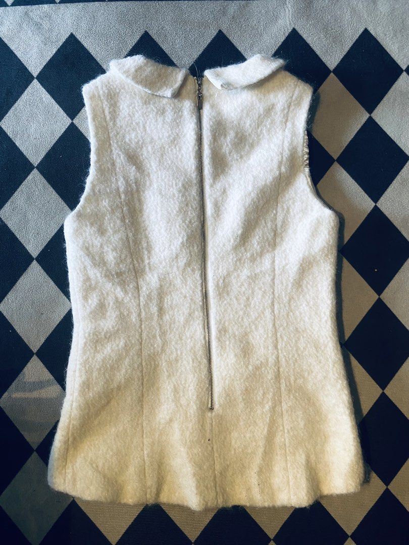 Chanel Sleeveless Vest with Collar (Category: Sleeveless) located in Sindangan. Submitted by vhonearnie (Listing ID 1438123847, Image 2). Description: - White Chanel sleeveless mohair wool vest featuring a Peter Pan collar with heart-shaped logo charms and zipped pockets. - Unique collar design - Two front zipper pockets - Full-length back zipper - Visible interior lining - Made in China - Size: L -Width 16 -Length 24 -Need wash only.