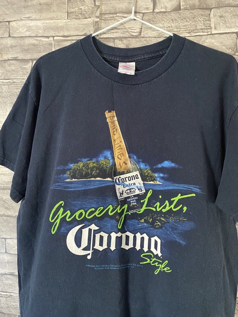 Corona Extra Grocery List T-shirt (Category: Tshirts & Polo Shirts ) located in Lingayen. Submitted by ivansellstuff (Listing ID 1438158214, Image 2). Description: - Navy blue Corona Extra t-shirt - Features a graphic of a Corona bottle on an island - Includes the text "Grocery List, Corona Style" - Standard crew neck design - Brand name visible.