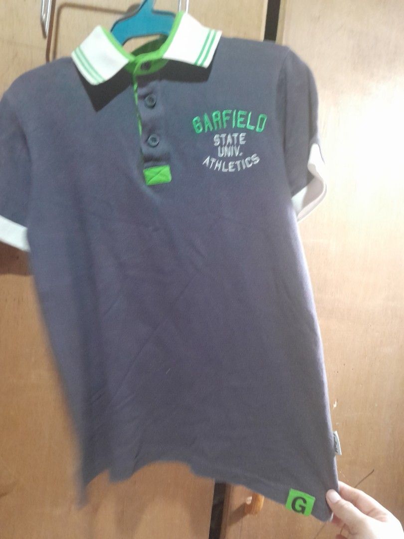 Garfield poli shirt (Category: Babies & Kids Fashion) located in Manila. Submitted by maceler (Listing ID 1438121572, Image 2). Description: - Garfield State University Athletics polo shirt - Dark gray color - collar green and white accents - Garfield logo patch on sleeve cuff - Large size on tag - Size 7-9 depends on the size of kids.