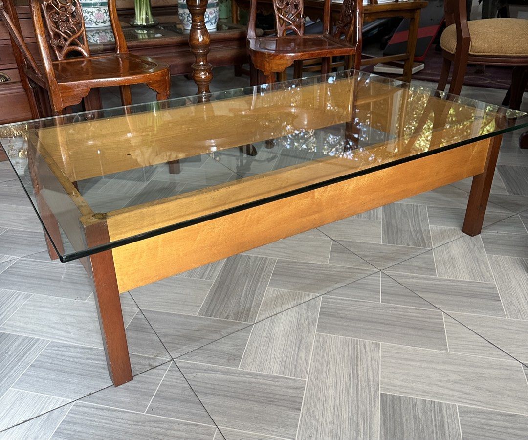 Glass Top Coffee Table (Category: Tables & Sets) located in Quezon City. Submitted by cddelarrazabal (Listing ID 1438191805, Image 1). Description: #greatasianfinds A striking rectangular wooden coffee table with glass top, showcasing a clean, architectural silhouette. The exposed wooden supports beneath the glass highlight its minimalist, structural design—a look often associated with mid-century modern and brutalist influences. Size: 48” L x 29