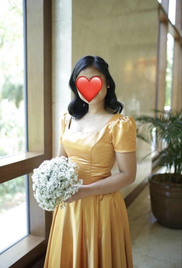 Gold Bridesmaid Dress (Category: Evening dresses & gowns) located in Cainta. Submitted by mulberry.co (Listing ID 1438259893, Image 2). Description: - Gold bridesmaid dress - Square neckline - Short, puffed sleeves - Fitted bodice - Floor-length skirt - Ideal for weddings and formal occasions - Solid gold color.