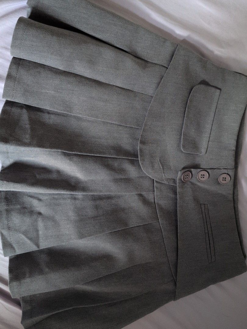 Gray Pleated Skirt (Category: Skirts) located in Cebu City. Submitted by wearthyy (Listing ID 1438197814, Image 2). Description: - Gray pleated skirt - Unique waistband with button details - Features pocket accents - Made of textured fabric - Classic and versatile style.